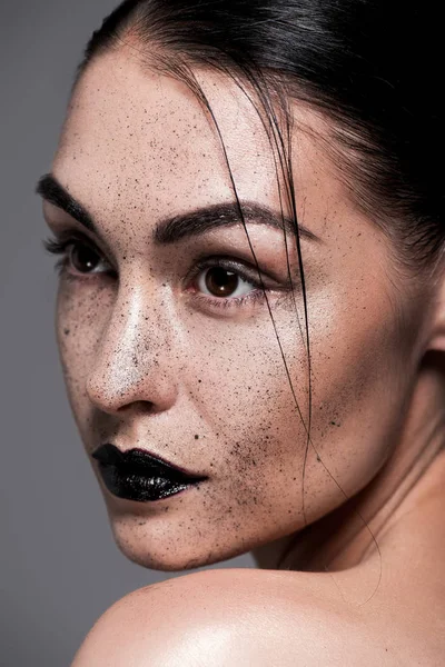 Modelo atractivo con labios negros y pecas, aislado en gris - foto de stock