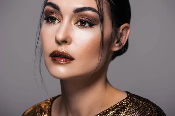 Portrait of beautiful fashionable girl posing in golden clothes, isolated on grey — Stock Photo