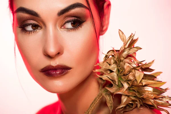 Retrato de menina elegante com girassol dourado posando para tiro de moda, imagem tonificada vermelha — Fotografia de Stock