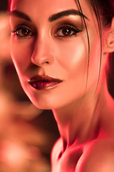 Портрет элегантной девушки с макияжем, красной тонированной картиной — стоковое фото