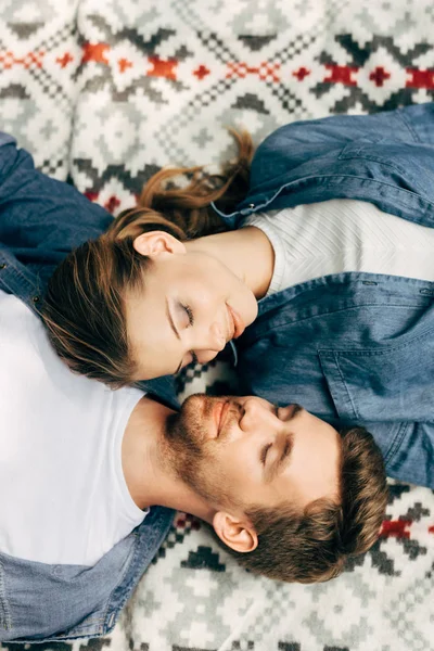 Vue de dessus de beau jeune couple relaxant sur tissu à motifs — Photo de stock