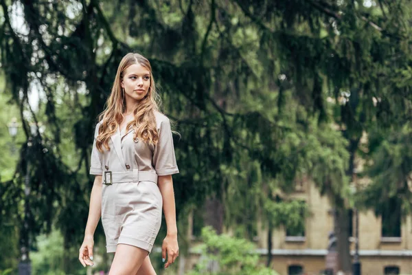 Hermosa joven en elegante general caminando por el parque - foto de stock