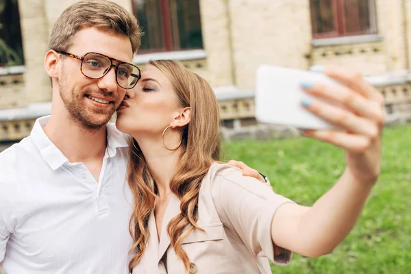 Beautiful young couple taking selfie while spending time together near old building — Stock Photo