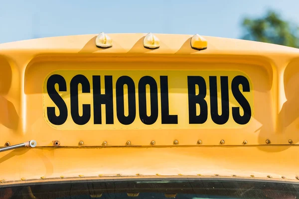 Primo piano dell'iscrizione dello scuolabus sopra il finestrino anteriore dell'autobus — Foto stock