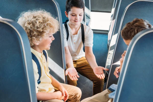 Group of adorable scholars having fun together while riding on school bus — Stock Photo