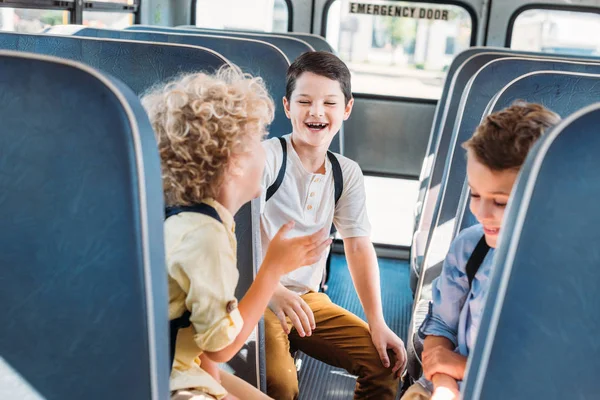 Gruppo di adorabili scolari divertirsi insieme mentre cavalcano su scuolabus — Foto stock