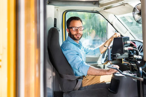 Schulbusfahrer sitzt im Bus und zieht Hebel — Stockfoto