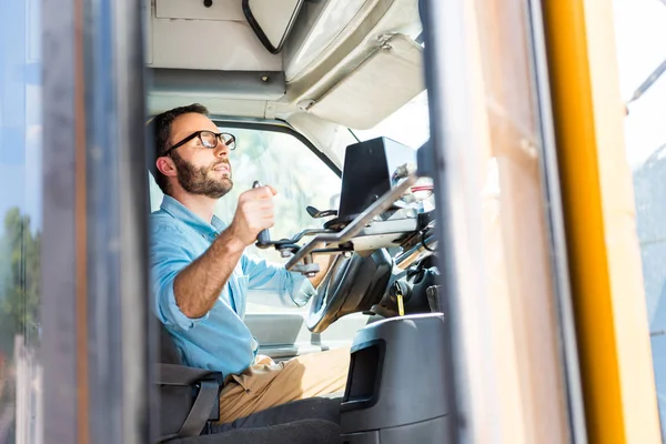 School bus driver losing door with lever and looking at rear mirror — Stock Photo