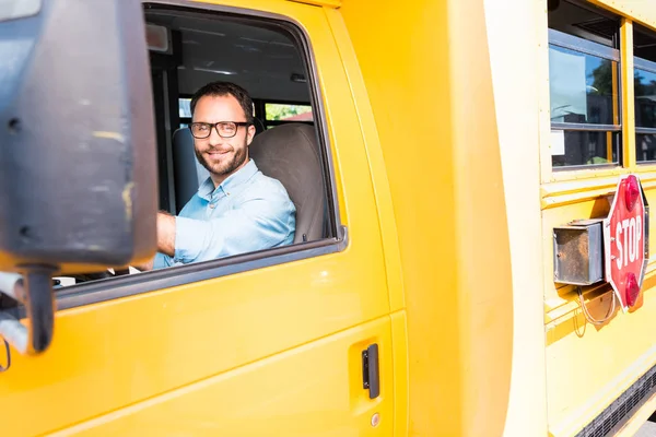 Attraktiver glücklicher Schulbusfahrer blickt in die Kamera — Stockfoto
