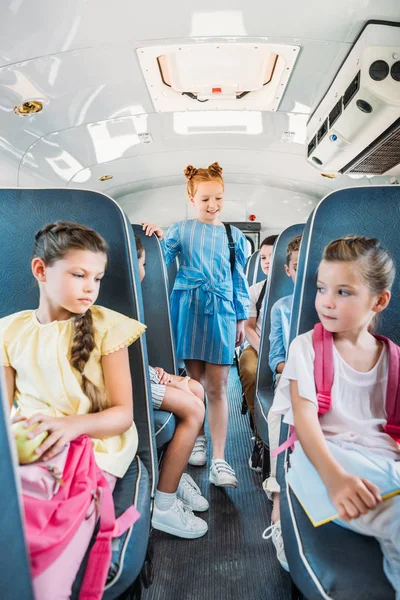 Grupo de escolares adorables que viajan en autobús escolar - foto de stock