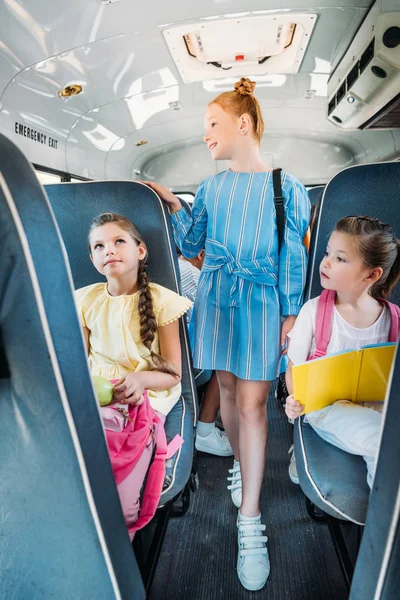 Gruppe entzückender Schulmädchen reitet auf Schulbus — Stockfoto