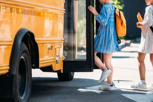 Обрезанный снимок школьниц, входящих в школьный автобус — стоковое фото