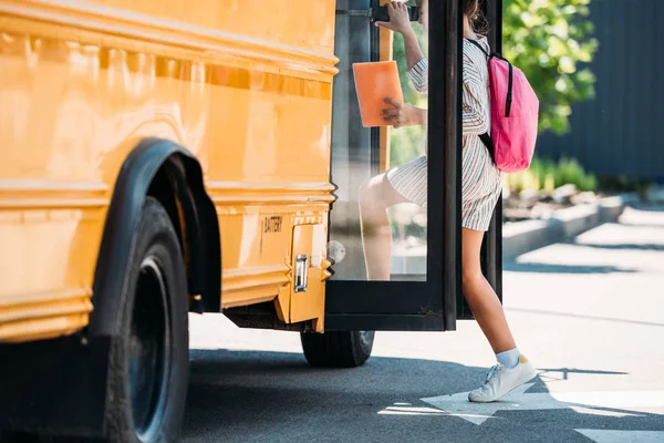 Cropped shot of schoolgirl entering school bus — Stock Photo