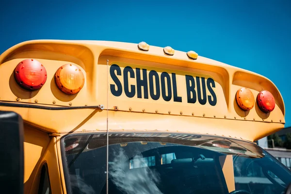 Gros plan de l'autobus scolaire avec panneau devant le ciel bleu — Photo de stock