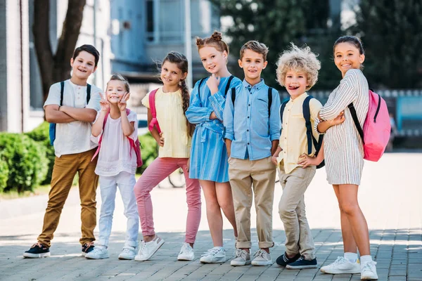 Группа очаровательных учеников, позирующих в школьном саду — стоковое фото