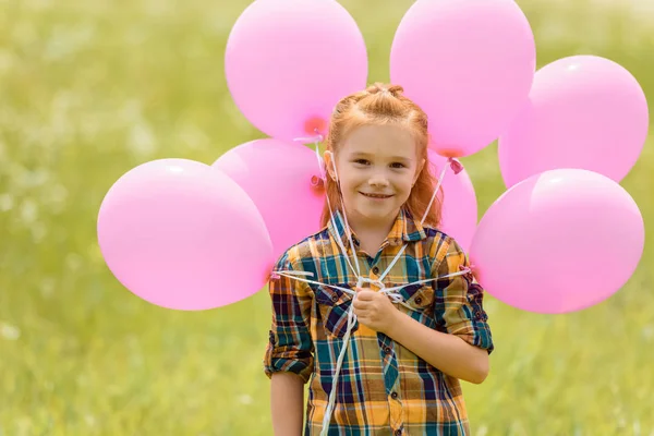 Ritratto di bambino carino con palloncini rosa nel campo estivo — Foto stock