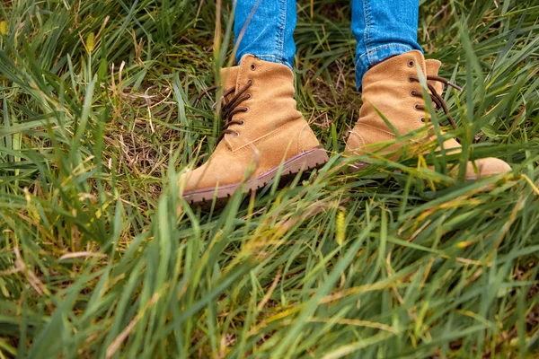Tiro cortado de pernas infantis em botas na grama verde — Fotografia de Stock