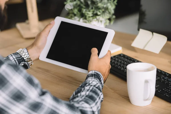 Recortado disparo de hombre de negocios utilizando tableta con pantalla en blanco en el lugar de trabajo - foto de stock