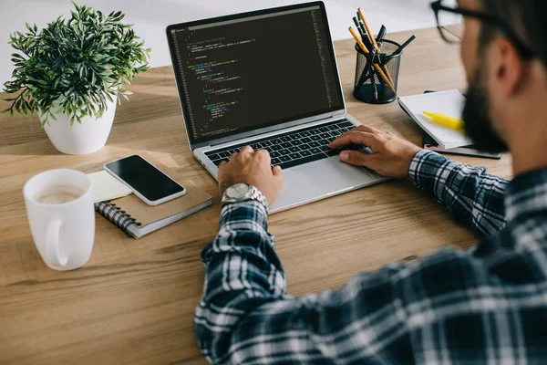 Tiro recortado de homem em camisa xadrez usando laptop com código de programa na tela — Fotografia de Stock