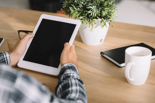 Recortado tiro de hombre en camisa a cuadros usando tableta en el lugar de trabajo — Stock Photo