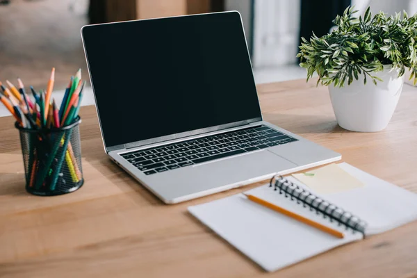 Ordinateur portable avec écran blanc debout sur le lieu de travail dans le bureau — Photo de stock