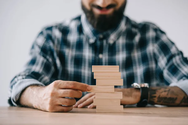 Vista ritagliata di uomo felice giocare gioco torre di legno — Foto stock