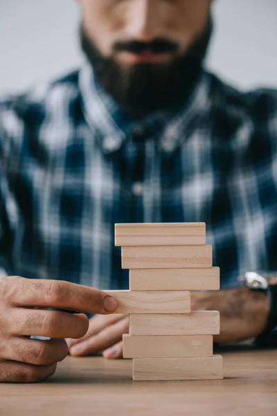 Vista recortada del hombre jugando con bloques de madera torre juego - foto de stock