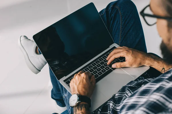 Vista recortada del hombre usando el ordenador portátil con pantalla en blanco - foto de stock