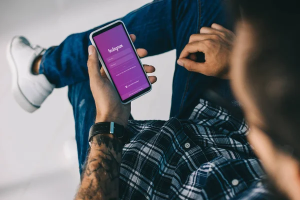 Vista recortada del hombre utilizando el teléfono inteligente con aparato instagram — Stock Photo