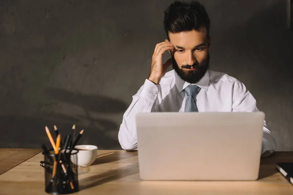 Nachdenklicher Geschäftsmann am Arbeitsplatz mit Laptop, Kaffee und Bleistift — Stockfoto