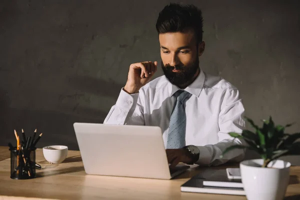 Bearded businessman working with laptop in office — Stock Photo