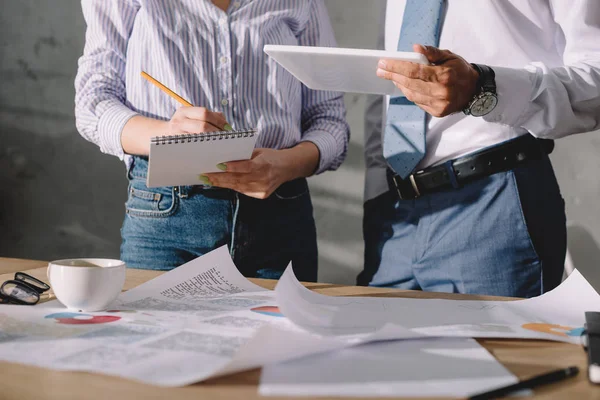 Vue recadrée des gens d'affaires en tenue de cérémonie travaillant avec des documents et tablette numérique — Photo de stock