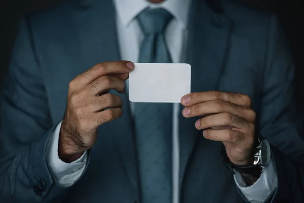 Cropped view of businessman in suit holding business card in hands — Stock Photo