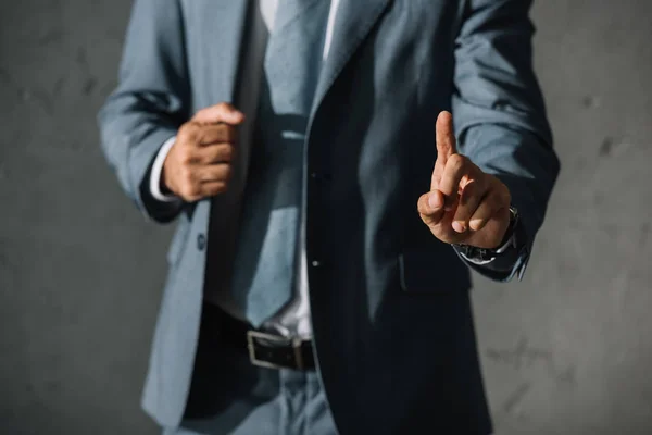 Vue recadrée de l'homme d'affaires en tenue de cérémonie pointant vers le haut — Photo de stock