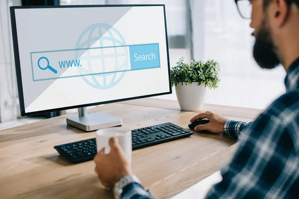 Cropped shot of seo manager with cup of coffee using computer with website — Stock Photo