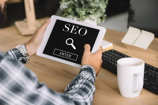 Abgeschnittene Aufnahme eines Entwicklers mit Tablet mit SEO-Suche — Stockfoto