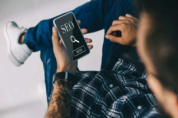Обрезанный представление SEO менеджер с помощью смартфона — стоковое фото
