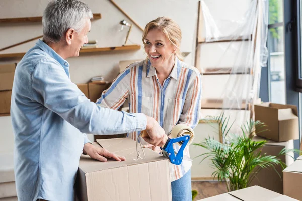 Heureux couple âgé emballage boîtes en carton lors de la relocalisation — Photo de stock