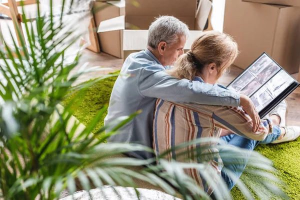 Vista ad alto angolo della coppia anziana guardando album fotografico mentre si trasferisce a casa — Foto stock