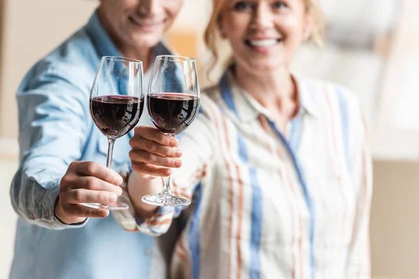 Tiro recortado de feliz casal de idosos segurando copos de vinho — Fotografia de Stock