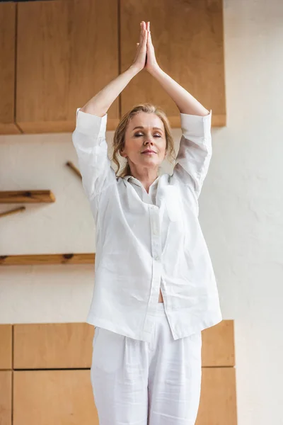 Beautiful sporty mature woman with closed eyes practicing yoga — Stock Photo