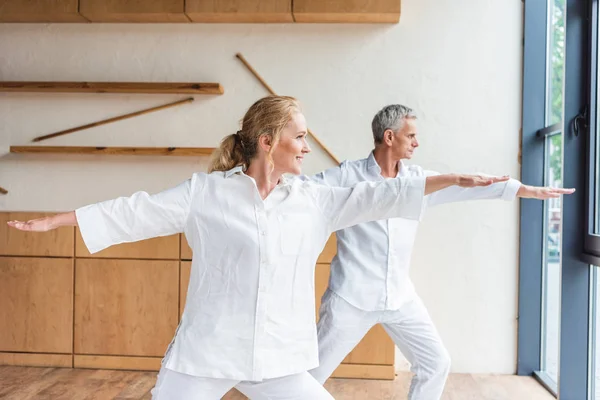 Feliz pareja de ancianos practicando yoga juntos - foto de stock