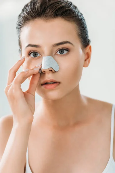 Schöne fokussierte Mädchen Anwendung Nasenstreifen im Badezimmer — Stockfoto