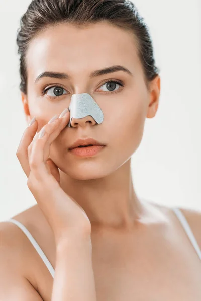 Beautiful girl applying nose strip in bathroom — Stock Photo