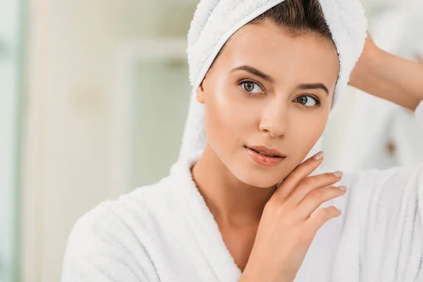 Portrait of beautiful young woman in bathrobe and towel on head — Stock Photo