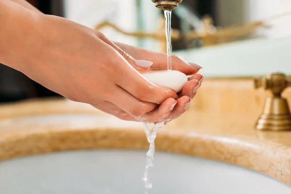 Primer plano vista parcial de la mujer lavándose las manos con jabón en el baño - foto de stock