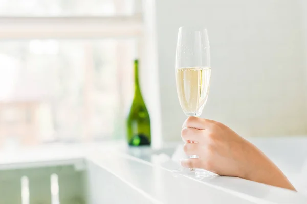 Nahaufnahme einer jungen Frau, die Champagner in der Badewanne trinkt — Stockfoto