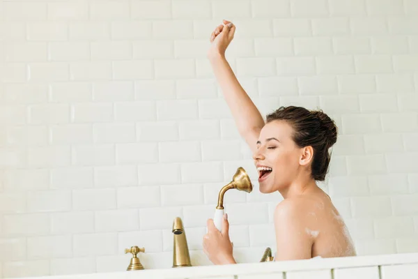Hermosa chica feliz cantando y divertirse en la bañera — Stock Photo