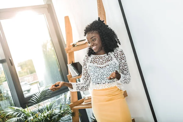 Portrait d'une femme d'affaires afro-américaine souriante debout dans un bureau moderne — Photo de stock