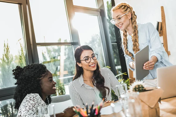 Groupe multiculturel de jeunes femmes d'affaires travaillant avec tablette ensemble — Photo de stock